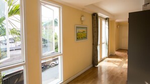 A hallway with large windows, a door, and a radiator. - Triple Palms House (Chiang Mai)