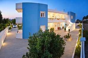 A modern building with a blue facade, multiple balconies, and a central staircase. - Nephele Apartments (Rhodes)