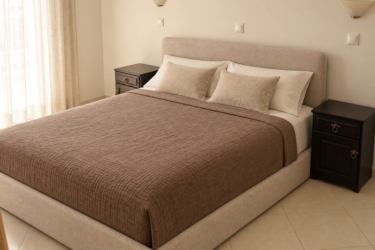 Un dormitorio con cama, mesitas de noche y apliques de pared.