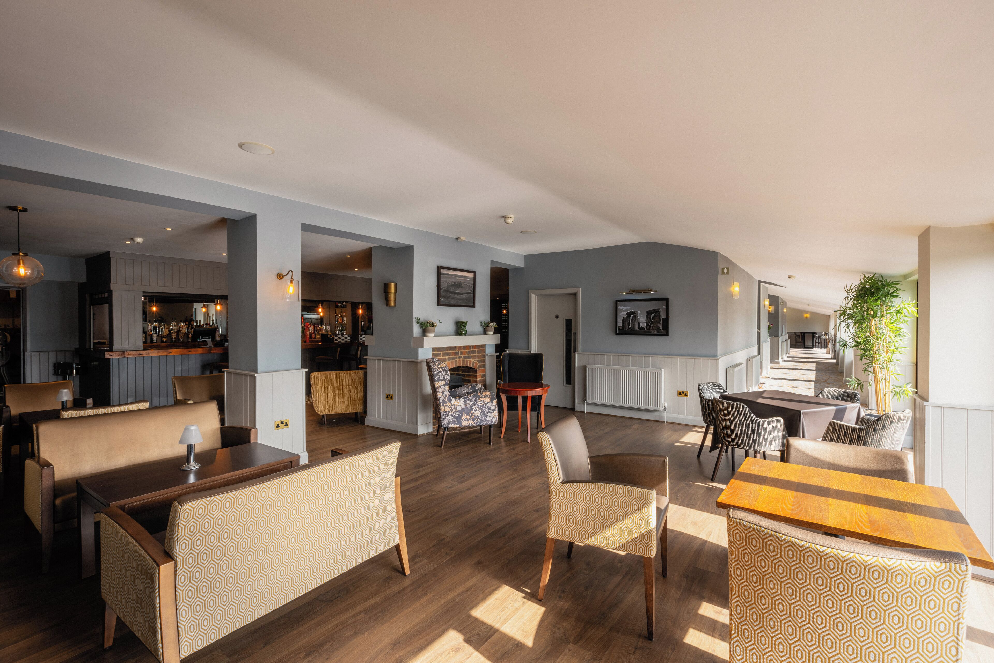 A spacious living area with a fireplace, seating arrangements, and a bar area.