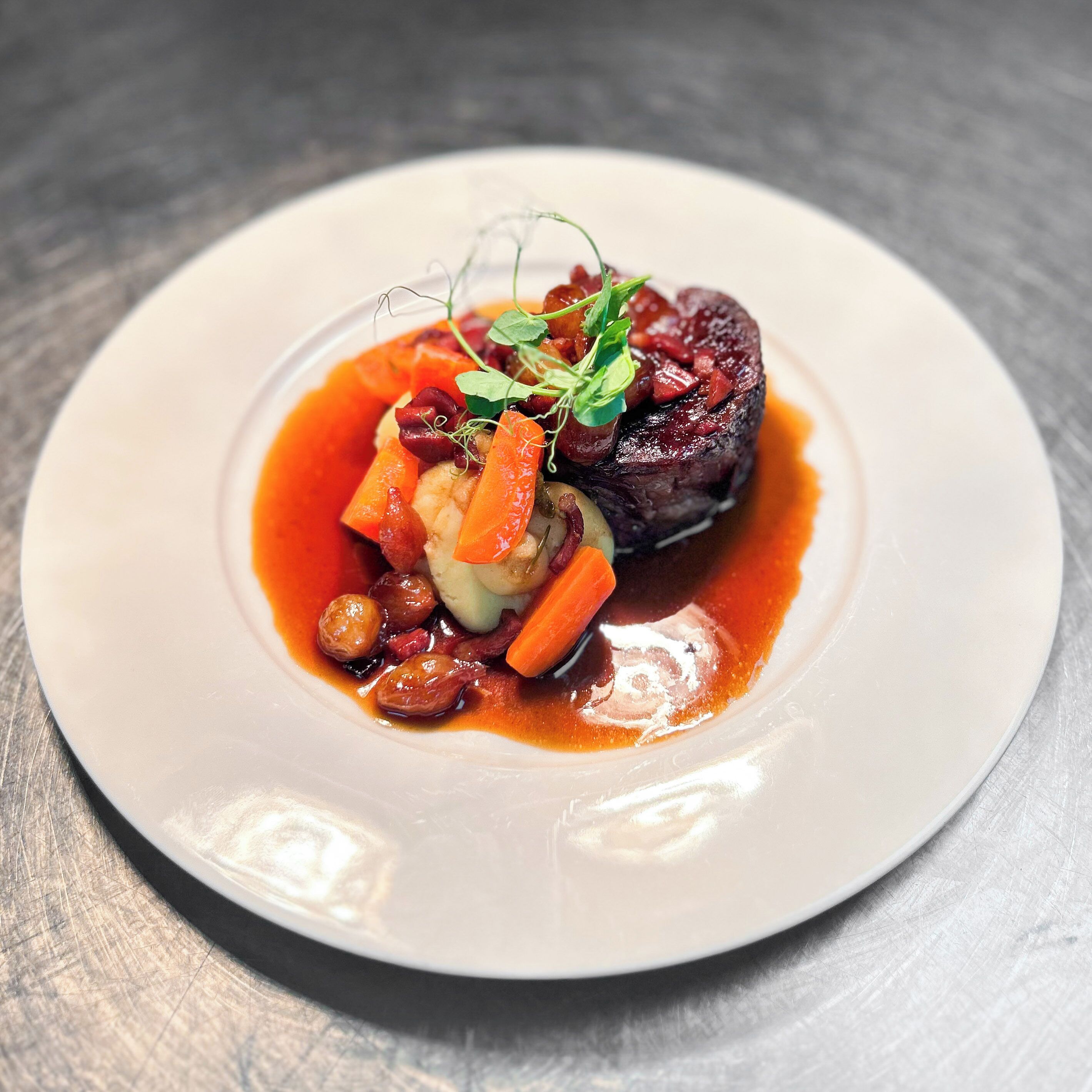Plat de menjar amb carn, verdures i una salsa.