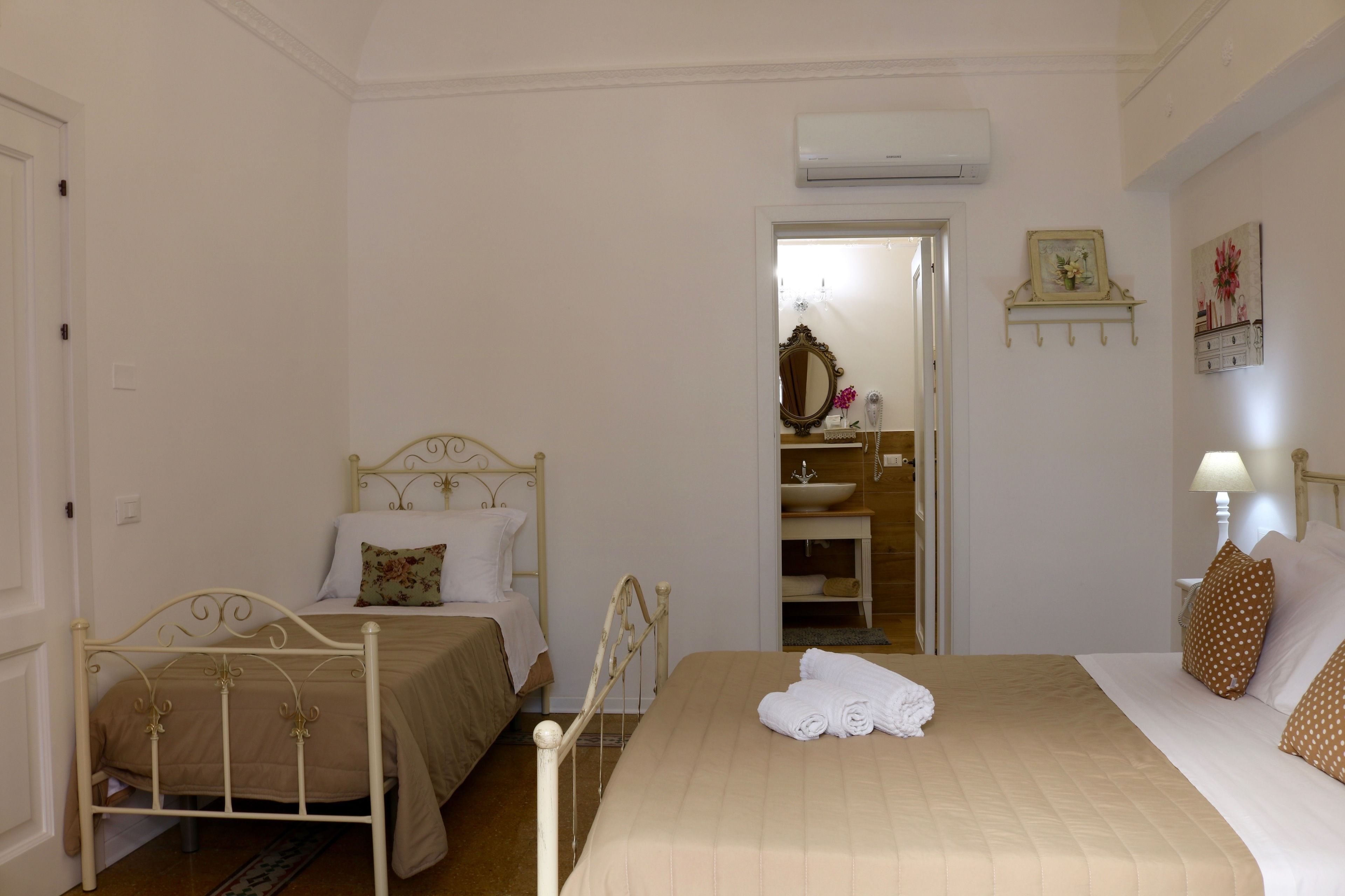 Ein Schlafzimmer mit zwei Betten, einem Badezimmer und einem Flur.