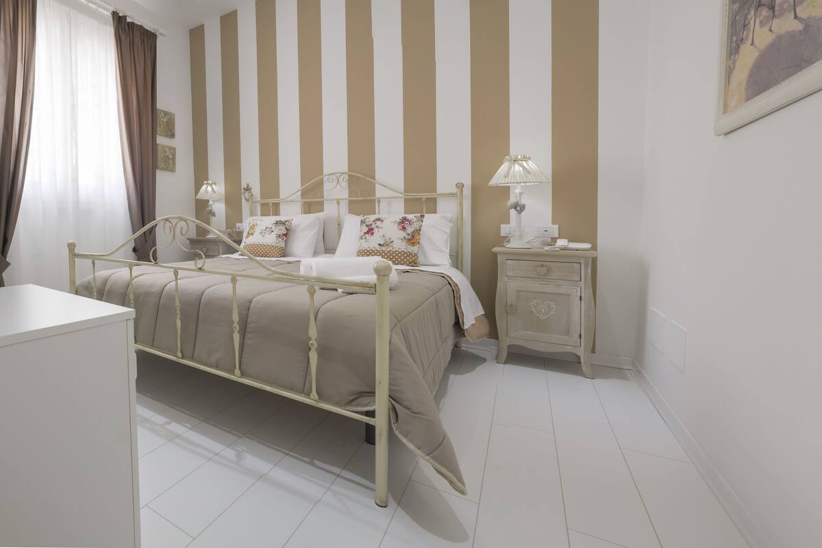A bedroom with a bed, bedside tables, and a nightstand.