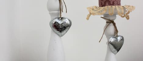 Two white candle holders with decorative elements.