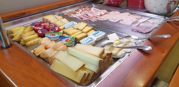 A buffet with various cheeses, meats, and yogurt containers. - Hotel Restaurant le Faudé (Lapoutroie)