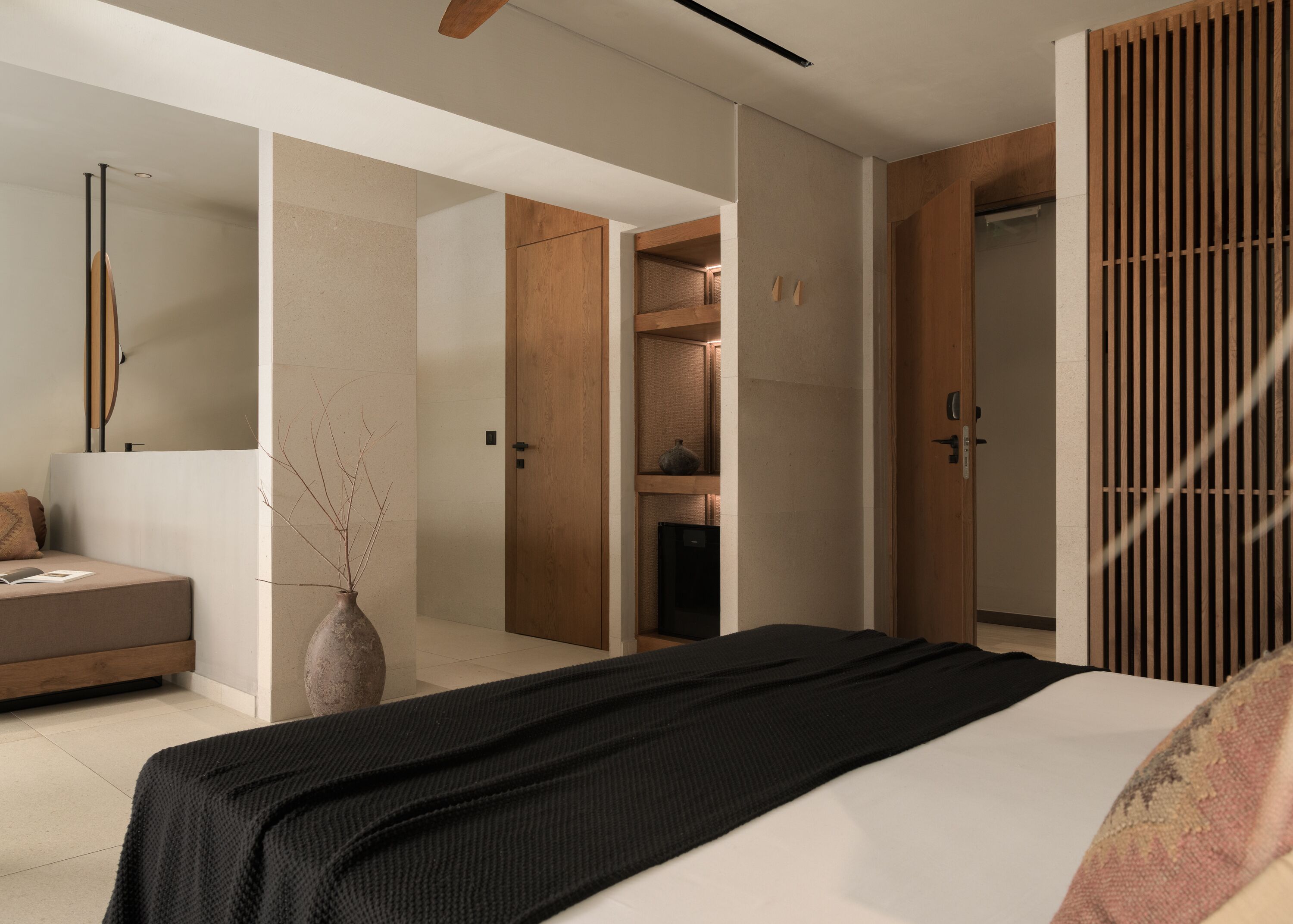 A modern bedroom with a large bed, a bedside table, a nightstand, and a wardrobe.