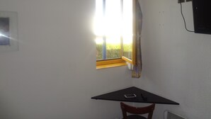 A room with a window, a table, and a chair. - Rev'Hotel Coignières (Coignieres)