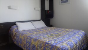 A hotel room with a bed, a nightstand, a wall-mounted TV, and a framed picture on the wall. - Rev'Hotel Coignières (Coignieres)