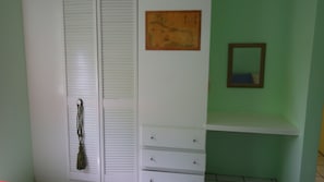 A room with a white wardrobe, a green wall, and a small shelf. - Harmony Hall Resorts (Choppins)