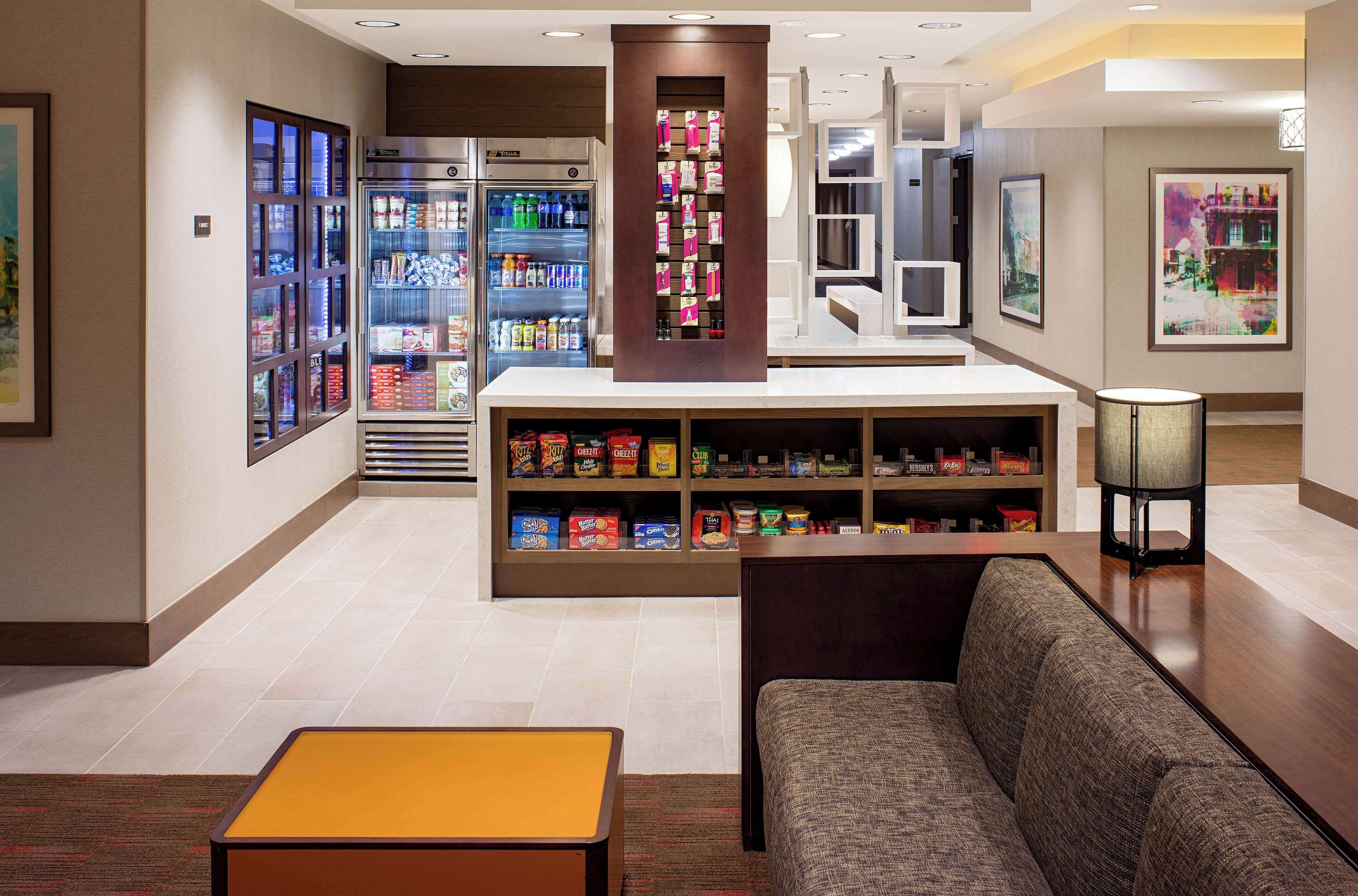 A hotel lobby with a seating area, a vending machine, and a snack bar.