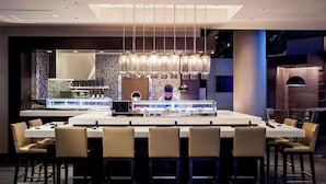 Un espace de restauration moderne doté d’un îlot central, de plusieurs options d’aménagement pour s’asseoir et d’un coin bar.