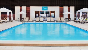 Un espace piscine avec des chaises longues et un comptoir d’accueil.