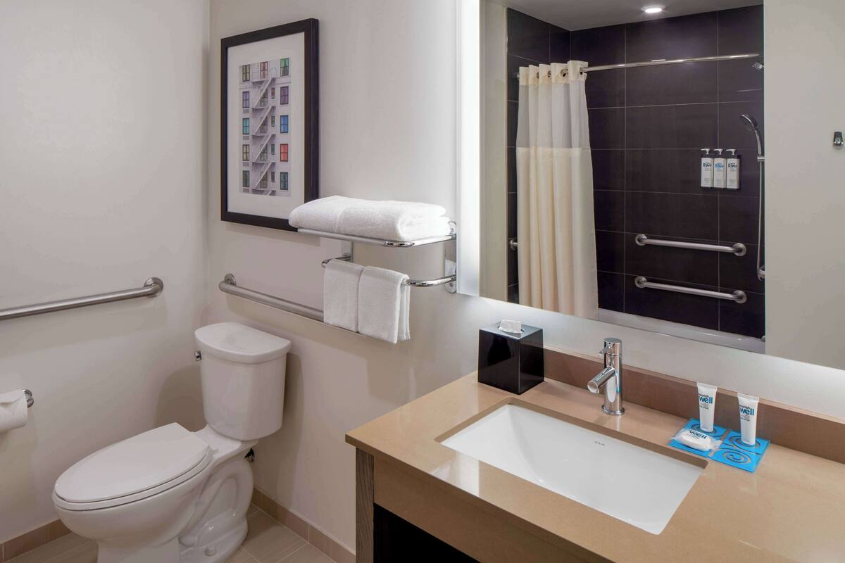 Une salle de bain moderne équipée de toilettes, d’un lavabo et d’une zone douche.