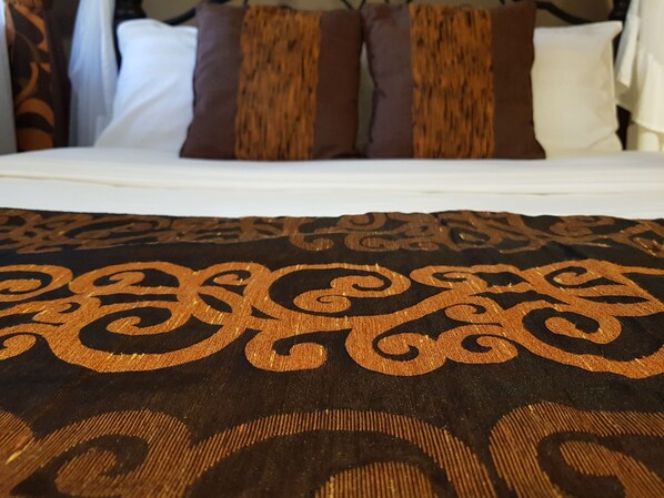 A bed with a patterned bedspread and pillows.