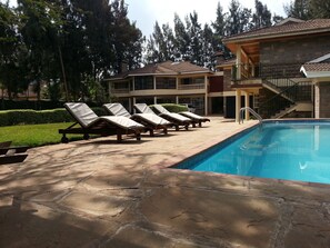 Alberca al aire libre y camastros