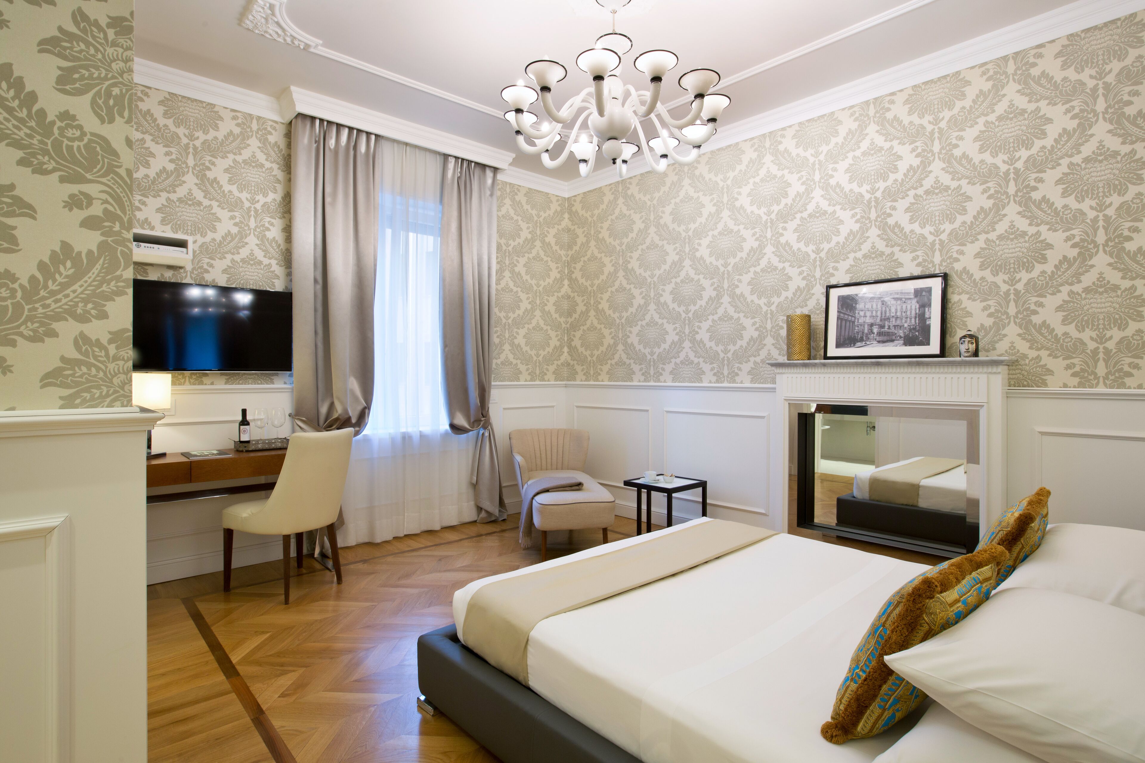 Une chambre d’hôtel équipée d’un lit, d’un bureau, d’une chaise, d’une télévision et d’une cheminée.