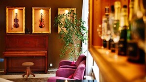 Une pièce avec un piano, un violon et une plante.