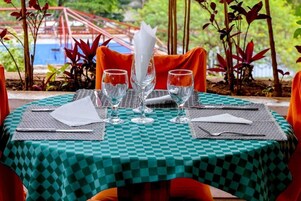 Mesa dispuesta para comer con mantel a cuadros, vasos transparentes y servilleta doblada.