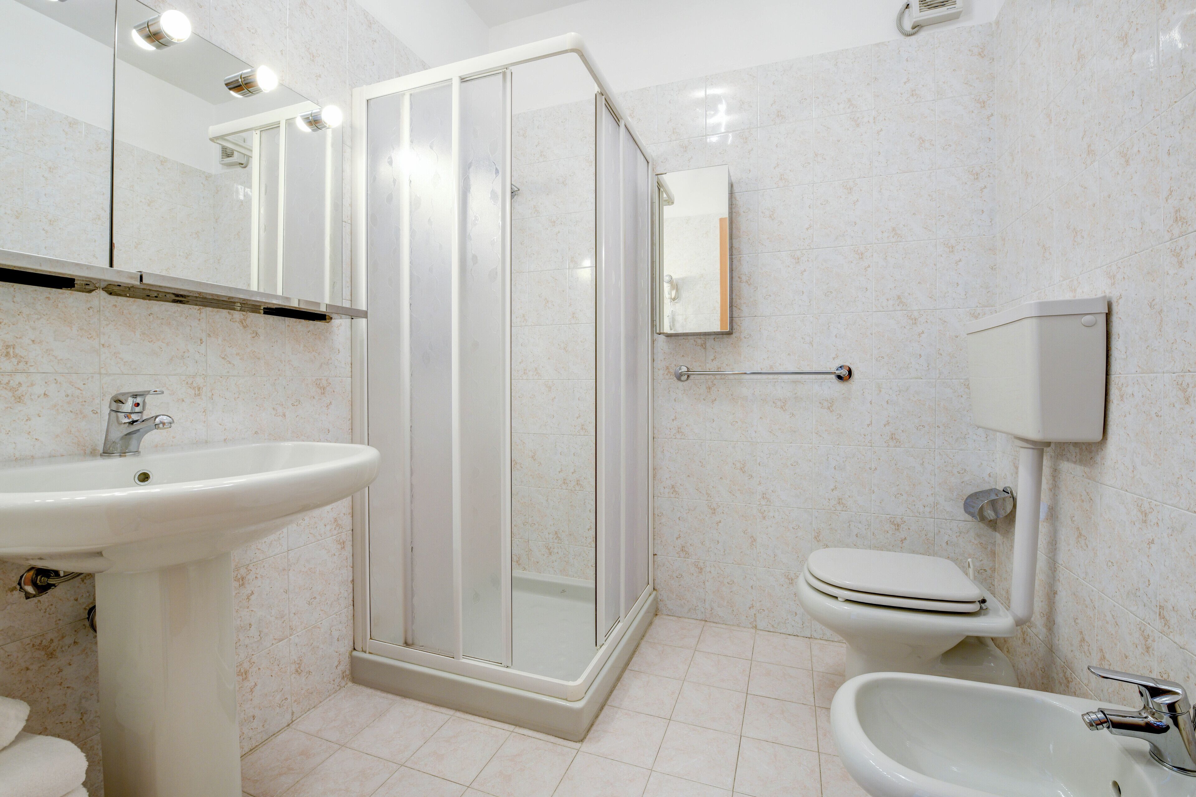Un bagno con doccia, toilette, bidet e lavandino.