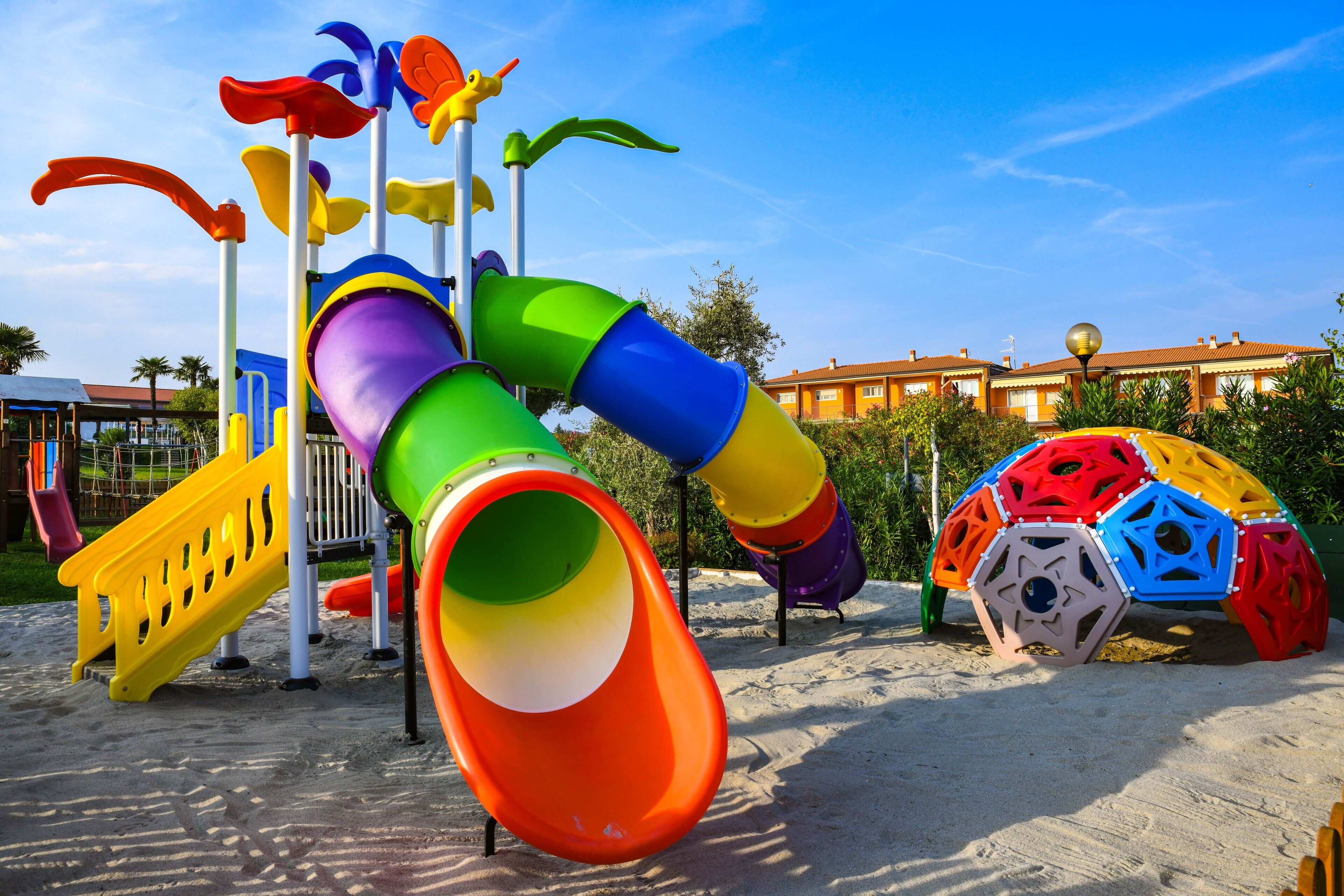 A playground with a colorful slide and climbing structures.