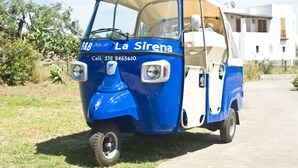 A blue and white three-wheeled vehicle with the text "La Sirena" and a contact number. - La Sirena (Lipari)