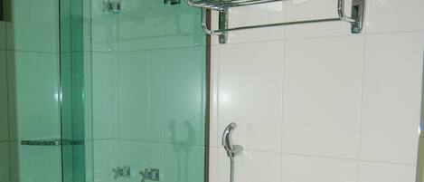 Un baño con cabina de ducha de vidrio, inodoro blanco y encimera de mármol.