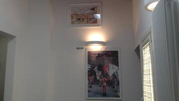 A room with a skylight, a radiator, and two framed pictures on the wall.
