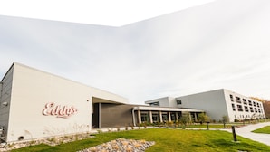 A modern building with a prominent 'Eddy's' sign on the facade, featuring a flat roof and a mix of glass and concrete materials. - Eddy's Resort (Onamia)
