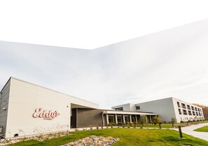 Experience the modern charm of Eddy's, set amidst a serene grassy area with a few trees.