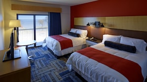 A hotel room with two beds, a desk, a lamp, and a view of the sea. - Eddy's Resort (Onamia)