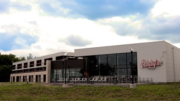 A modern building with a large glass facade and a sign reading "Eddy's".