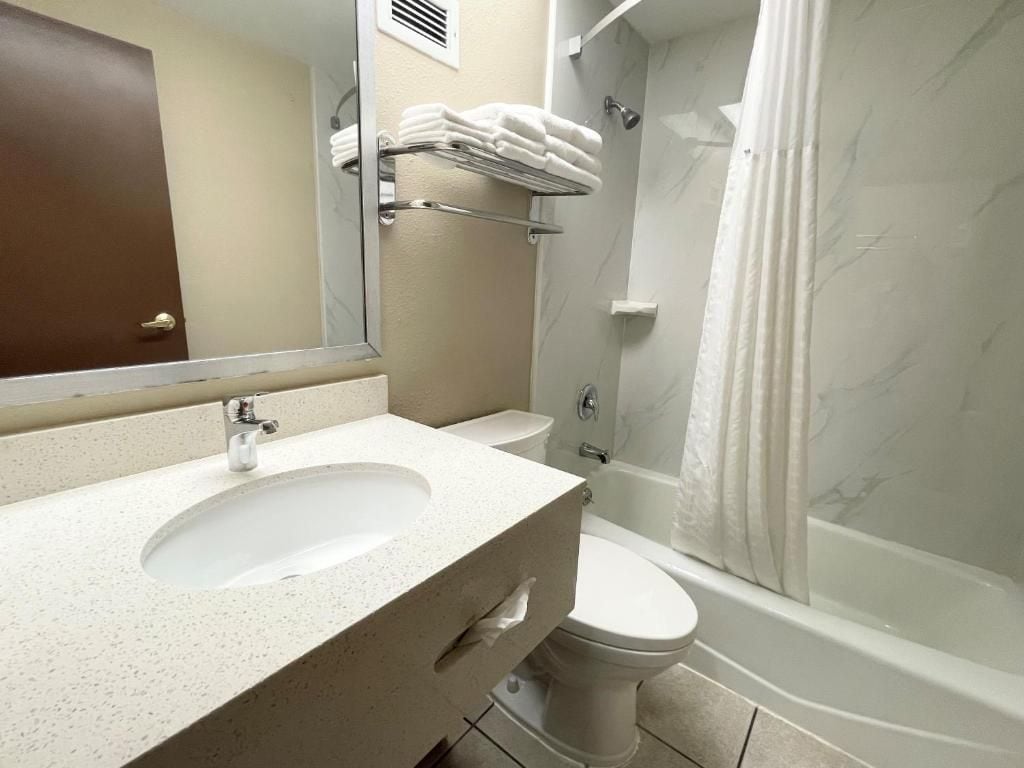 A bathroom with a sink, toilet, and shower.