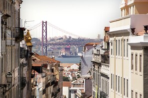 Vista de un paisaje urbano con un puente destacado al fondo, rodeado de edificios históricos con balcones y tejados de tejas.