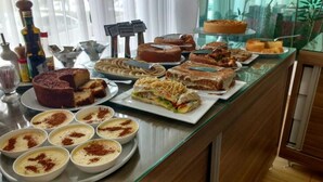 A buffet with various desserts and a coffee station. - Porto da Serra Hotel (Gravata)