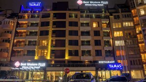 Un hotel con varios balcones, un restaurante y una señal de parada.