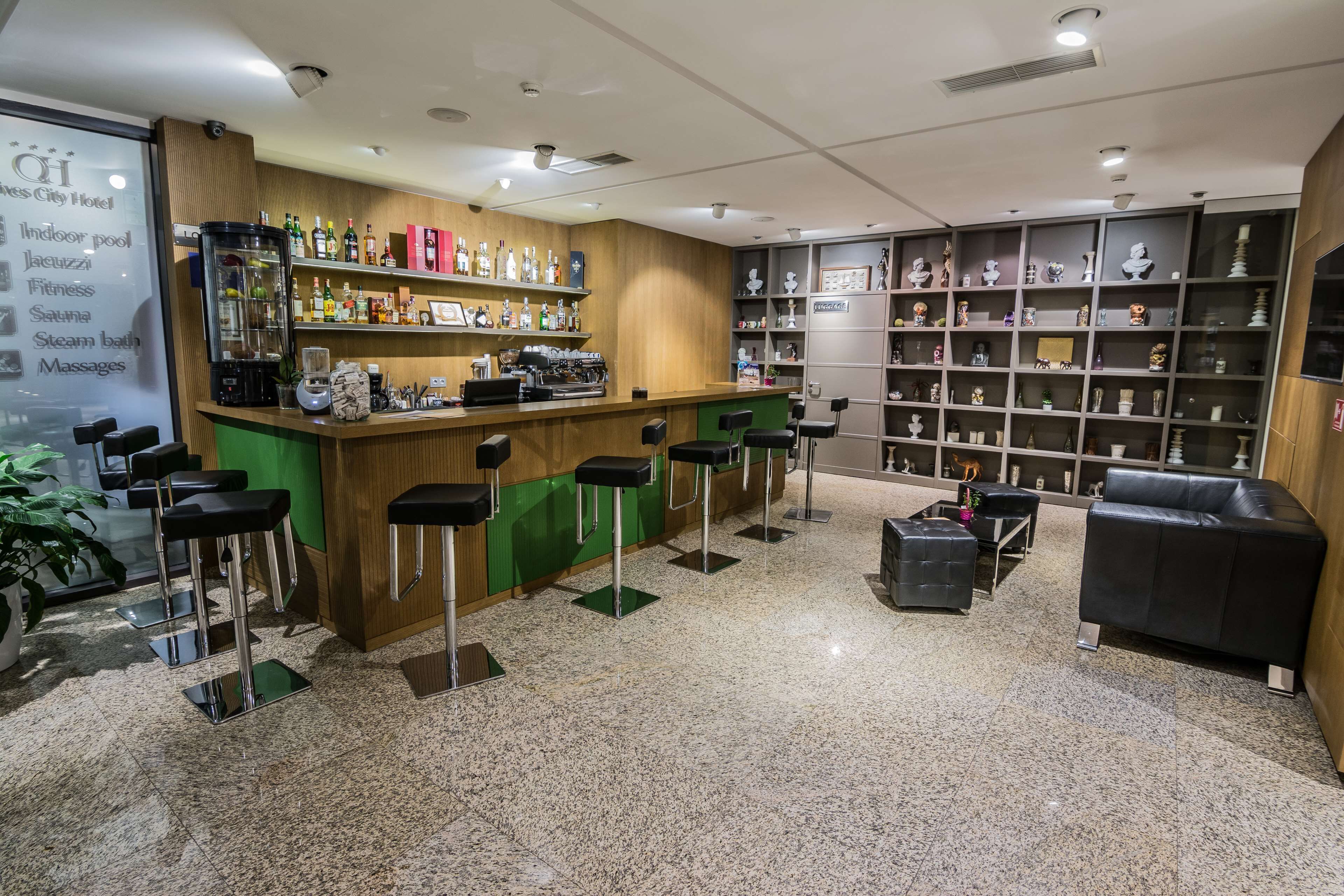 A bar area with stools, a coffee machine, and shelves with bottles.