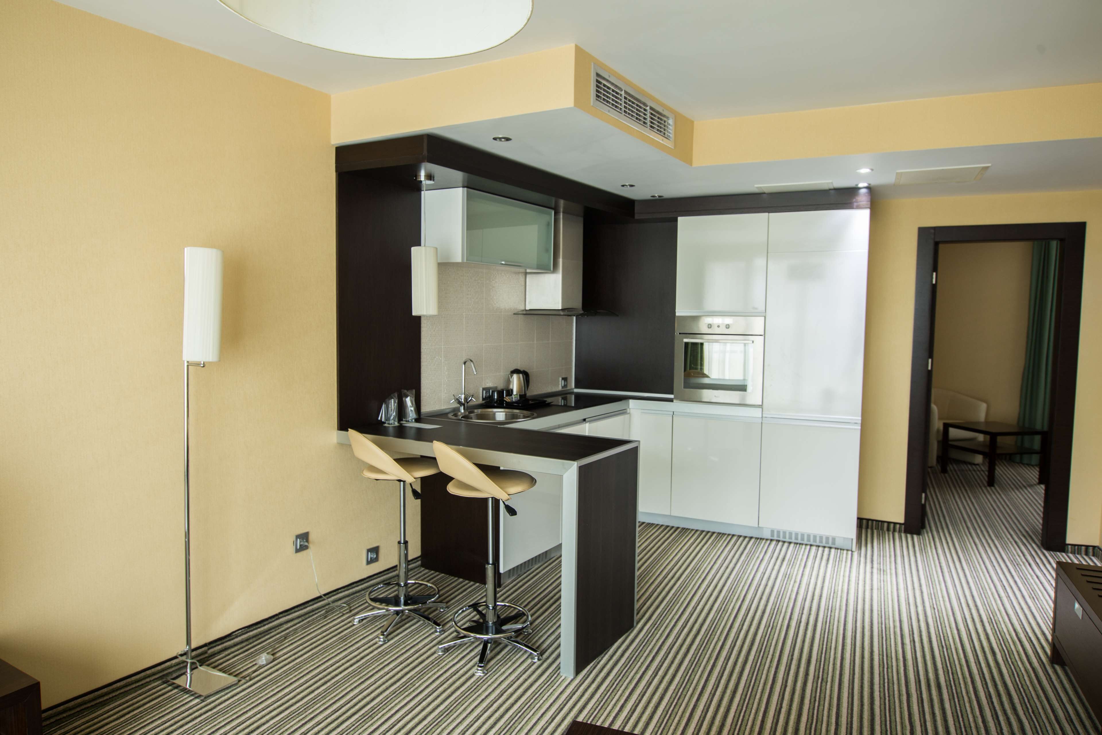 A modern kitchen with a bar area, a microwave, and a sink.