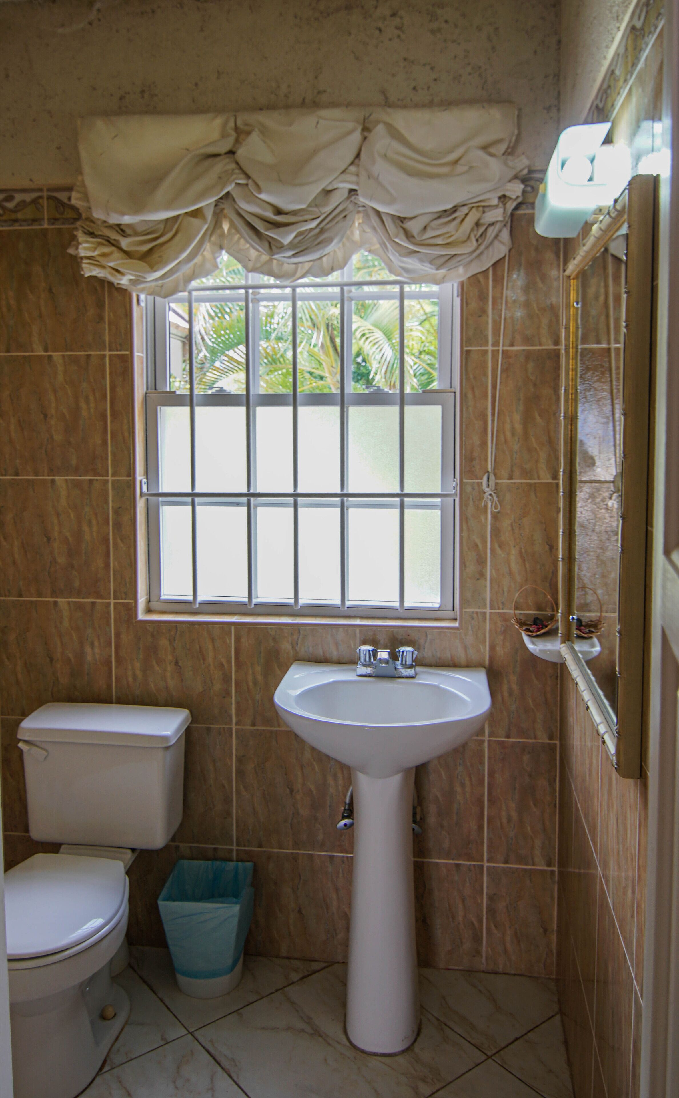 Un baño con inodoro, lavamanos y ventana.
