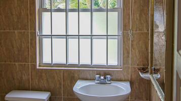 Un baño con inodoro, lavamanos y ventana.