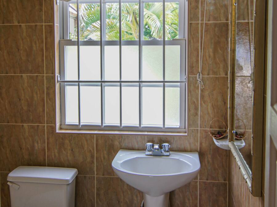 Un baño con inodoro, lavamanos y ventana.