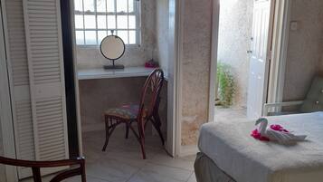 Un dormitorio con cama, escritorio y silla.