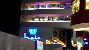 A hotel with a prominent neon sign reading "Amala" and a sign indicating a coffee shop. - Hotel Amala (Mexico City)
