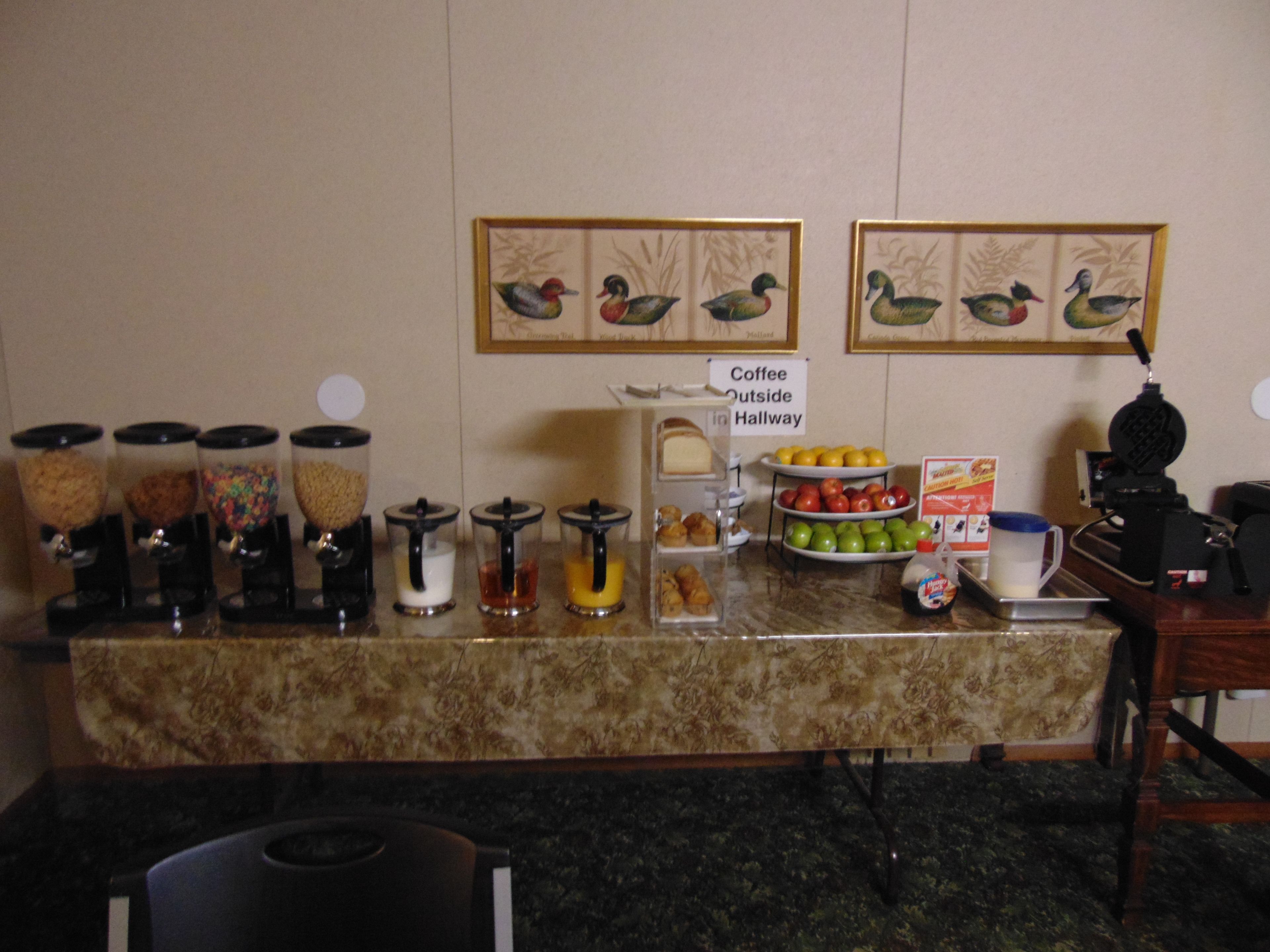 A breakfast bar with various food items and a coffee station.