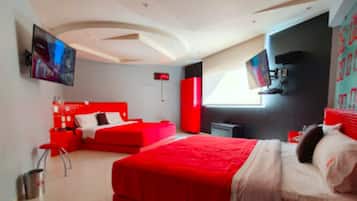 Un dormitorio moderno con una cama grande, un sofá rojo, un televisor y un armario rojo.