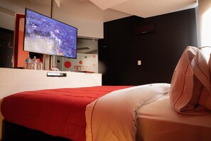 A hotel room with a bed, a TV mounted on the wall, and a red and white color scheme. - Love Hotel Kron (Mexico City)