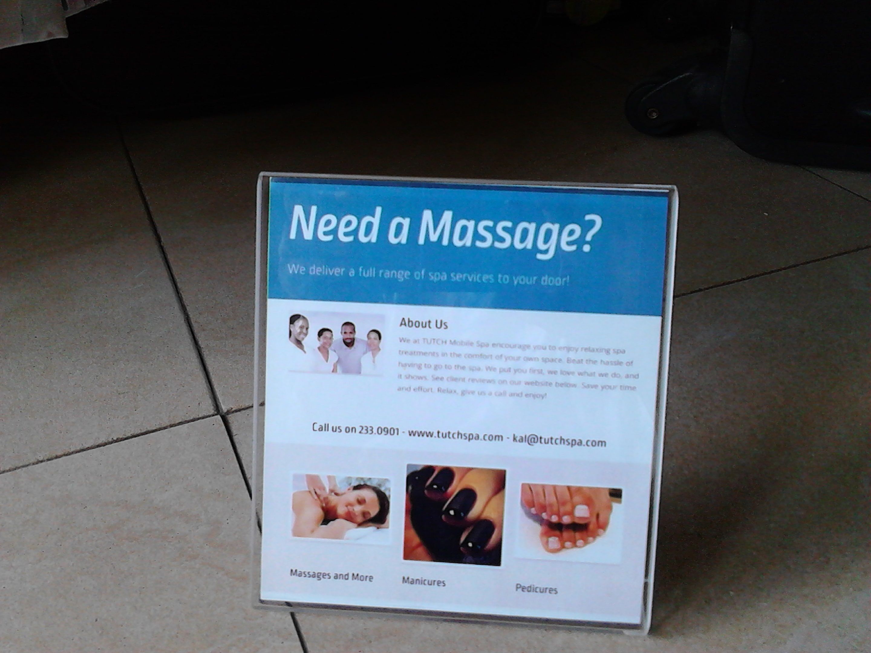 Une enseigne publicitaire annonçant des services de massage et indiquant les coordonnées.