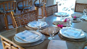 A dining table set with plates, glasses, and a menu. - Sea Symphony Villa (Fryers Well)