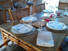 Una mesa de comedor dispuesta con platos, vasos y una carta.