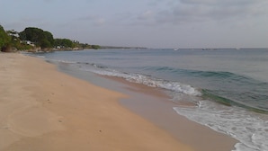 A beach with a sandy shore and gentle waves. - Sea Symphony Villa (Fryers Well)