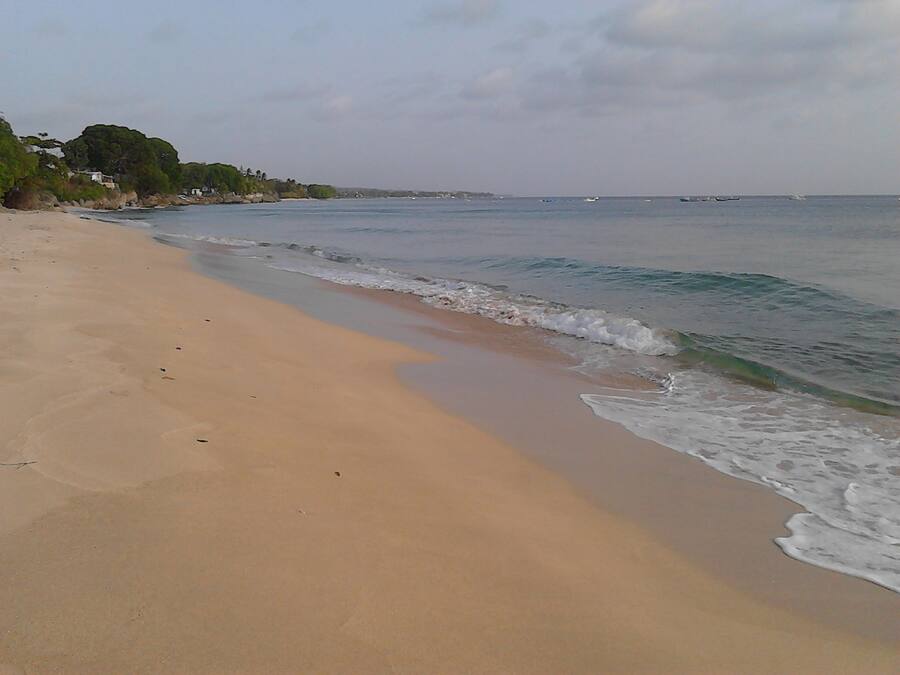 Una playa con arena y olas suaves.